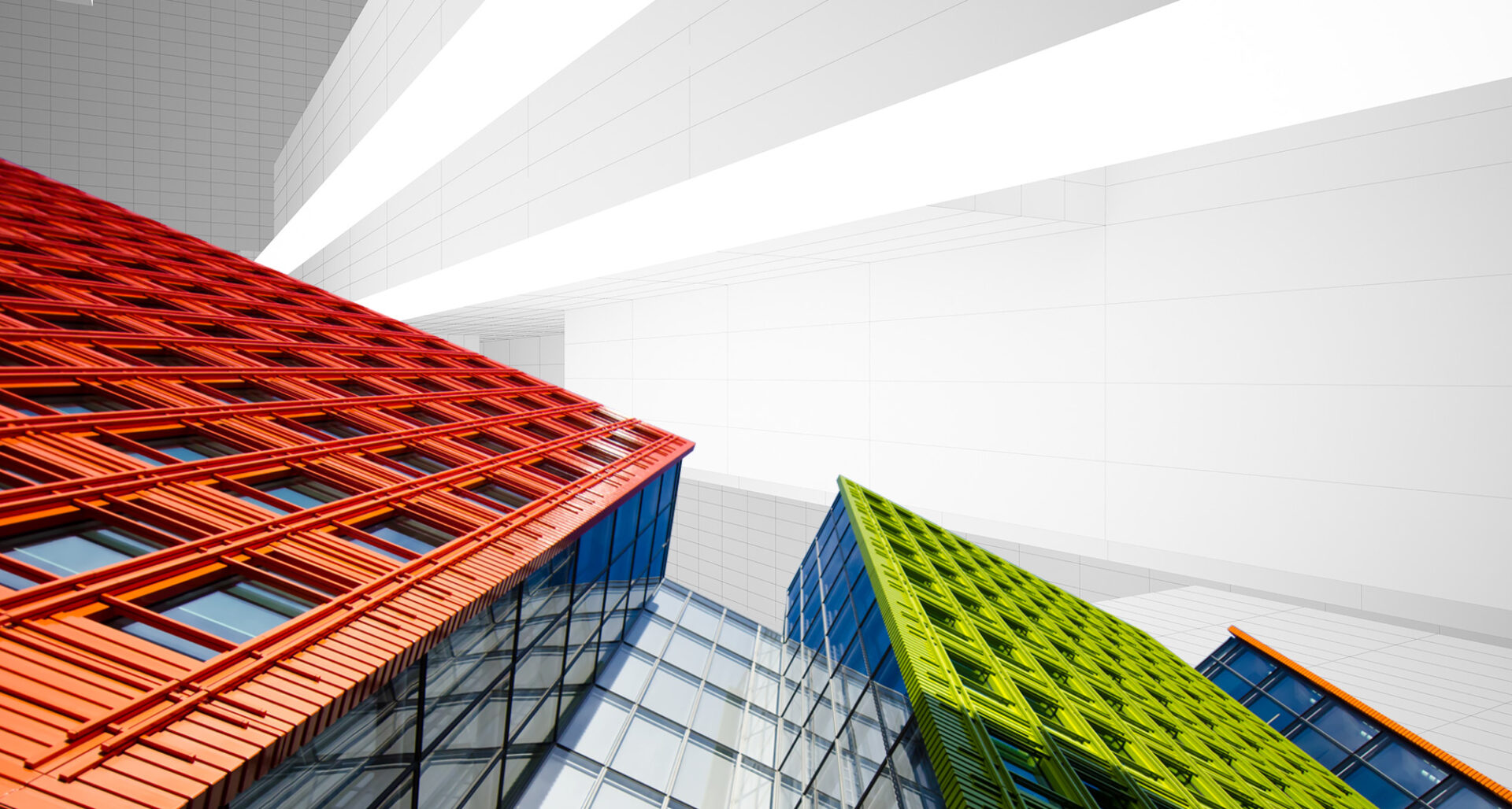 A view of three different colored buildings from below.